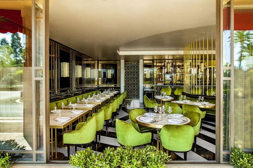 Nội thất nhà hàng sang trọng với sàn gạch đen trắng họa tiết độc đáo. Ghế bar bọc nỉ xanh nổi bật trong không gian quầy rượu cao cấp. Thiết kế nhà hàng view sân vườn thoáng mát với bàn ghế ngoài trời.