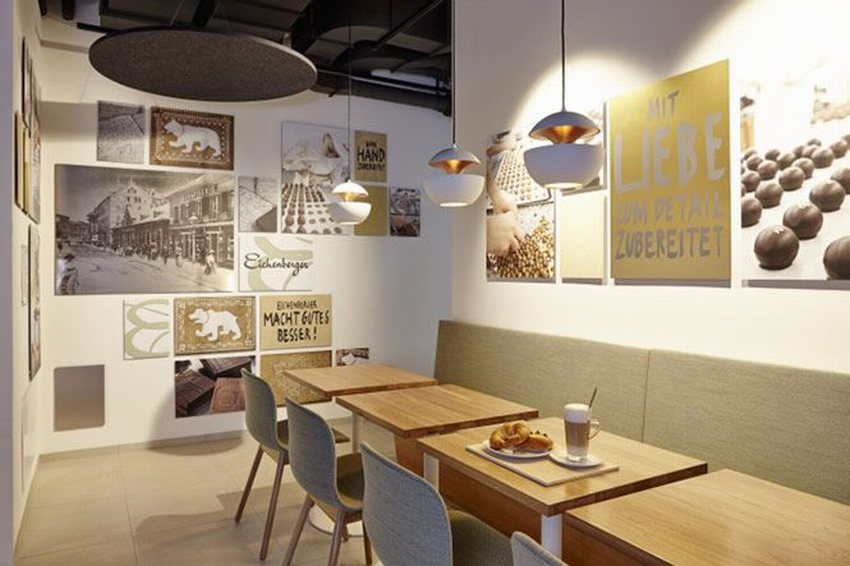 Khu vực ngồi của Baker Café mang phong cách tối giản, sử dụng bàn gỗ, ghế nệm êm ái và ánh sáng vàng dịu nhẹ. Tranh treo tường sáng tạo tạo nên không gian thưởng thức bánh và café ấm cúng, thoải mái.
