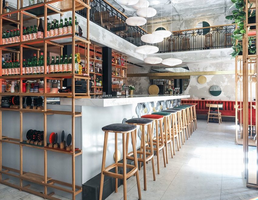 Không gian cafe bar kết hợp ánh sáng tự nhiên và đèn treo hiện đại. Quầy bar cafe rộng rãi với ghế cao bọc nệm đa dạng màu.