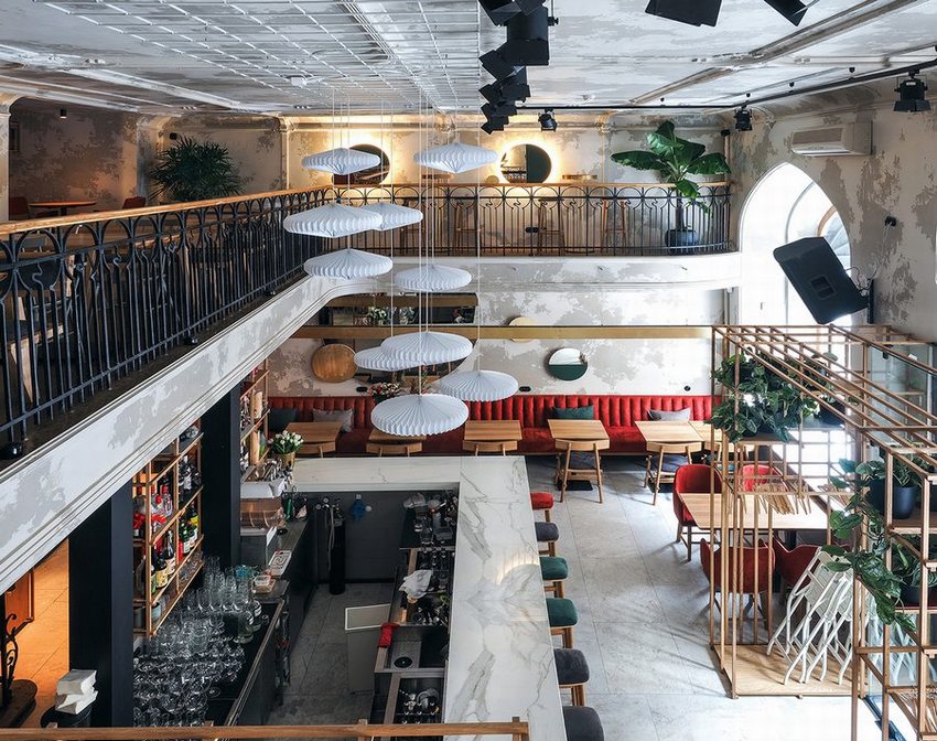Quán cafe bar hiện đại, kết hợp không gian ngồi nhóm và quầy bar. Thiết kế cafe bar độc đáo với trần cao, đèn treo nghệ thuật và cây xanh.