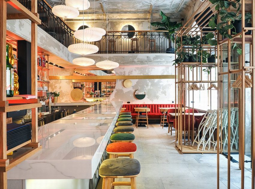 Không gian cafe bar thoáng đãng với cây xanh và ánh sáng tự nhiên. Thiết kế nội thất cafe bar sang trọng, ghế gỗ cao phối màu độc đáo.