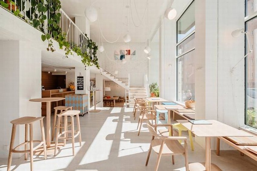 Thiết kế quán cafe hiện đại, tối giản với tông màu trắng chủ đạo, nội thất gỗ sáng và không gian ngập tràn ánh sáng tự nhiên, tạo cảm giác thoáng đãng và tiết kiệm chi phí.