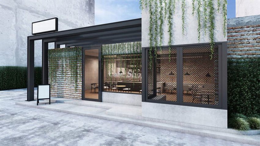 Mẫu thiết kế thi công quán cafe khung thép hiện đại với mặt tiền ấn tượng, kết hợp tường gạch, kính lớn và cây xanh rủ tạo điểm nhấn độc đáo.