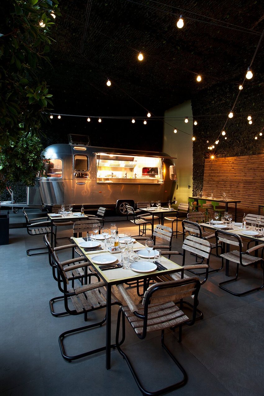 Ý tưởng thiết kế nhà hàng cafe kết hợp xe foodtruck hiện đại, không gian ấm cúng với bàn ghế tối giản và ánh đèn trang trí.