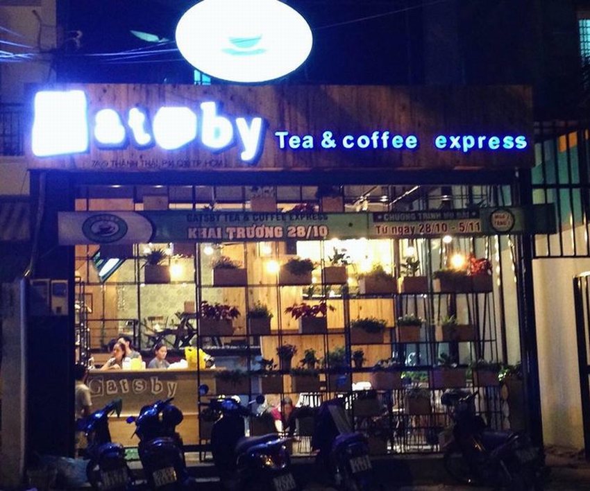 Mặt tiền quán cafe – trà sữa Gatsby Tea & Coffee Express với bảng hiệu nổi bật, không gian kính hiện đại và cây xanh trang trí.