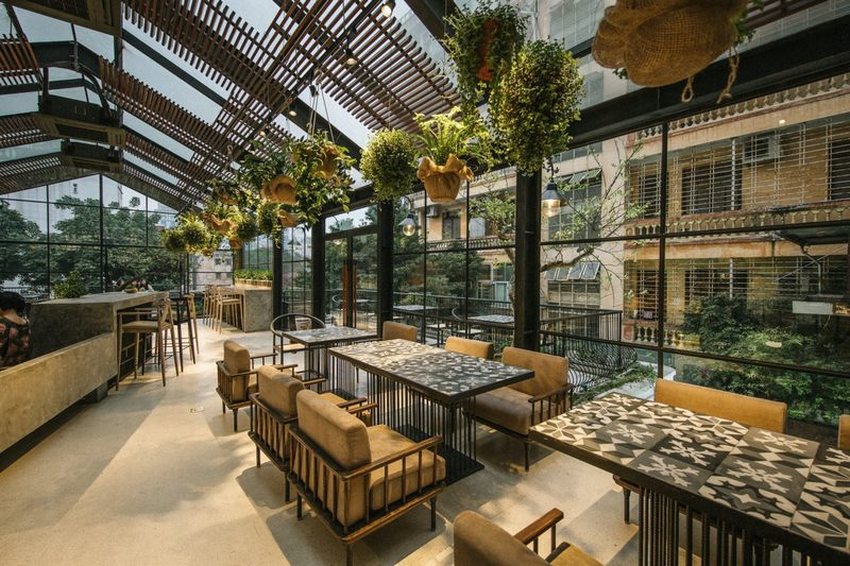 Không gian nhà hàng chay được thiết kế với hệ thống cửa kính lớn, trần cao thoáng đãng, kết hợp cây xanh treo trang trí tạo cảm giác gần gũi thiên nhiên và thoải mái cho thực khách. 