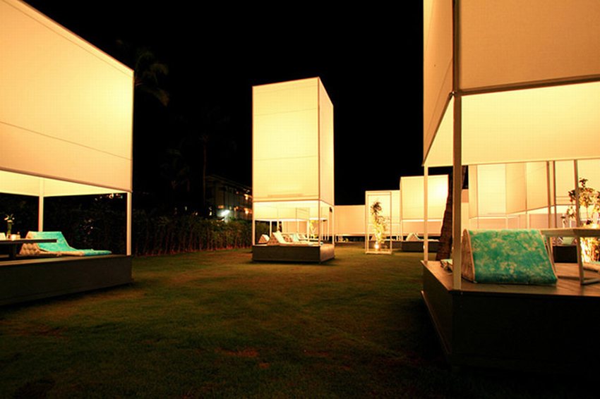 Không gian nhà hàng được thiết kế theo phong cách resort sang trọng, với các chòi riêng biệt trên nền cỏ xanh, ánh sáng vàng dịu