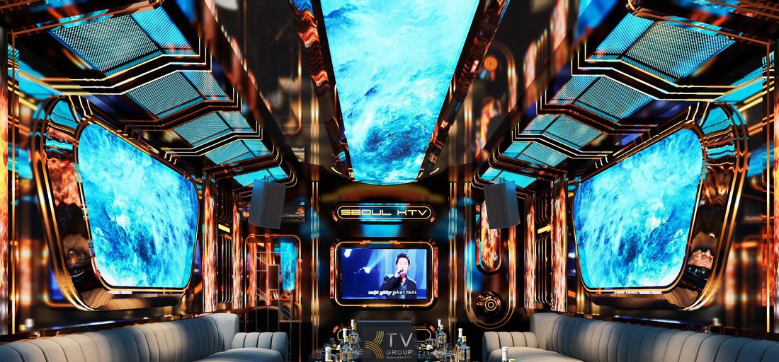 Không gian phòng karaoke KTV với màn hình trung tâm, trần LED dài và tường trang trí kim loại tạo phong cách giải trí công nghệ nổi bật.