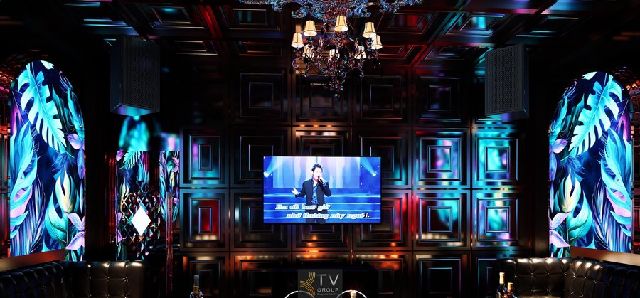 Thi công karaoke KTV Luxury Tropical tại Bảo Lộc với tường panel 3D ánh kim, tranh LED lá nhiệt đới và sofa da cao cấp, tạo không gian giải trí sang trọng, thu hút khách trẻ và khách du lịch. 