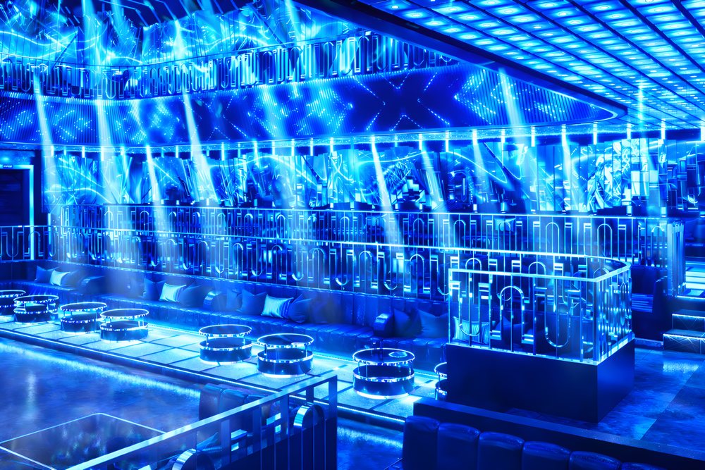 Gam màu xanh neon mang đến cảm giác công nghệ và sang trọng. Hệ thống ánh sáng được thiết kế để tạo chiều sâu, giúp không gian rộng hơn và thu hút khách hàng trẻ. 