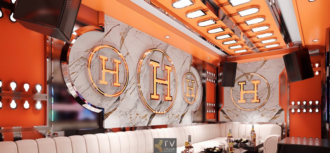Không gian karaoke luxury với logo chữ H nổi bật, tường marble cao cấp, hệ đèn LED hiện đại và nội thất sofa sáng màu mang lại trải nghiệm giải trí đẳng cấp.