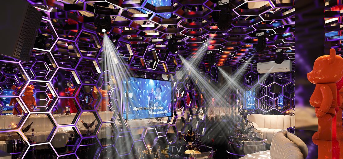 Thiết kế phòng karaoke KTV phong cách hiện đại với trần tổ ong ánh sáng LED đa màu, không gian sang trọng, bố trí sofa cao cấp và hệ thống đèn sân khấu tạo trải nghiệm giải trí ấn tượng tại TP.HCM 