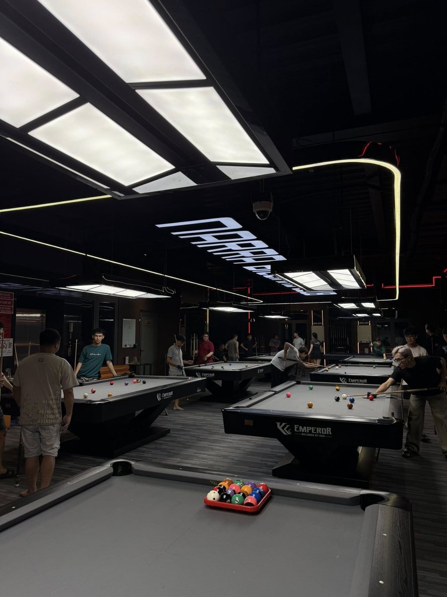 Không gian NARRA BILLIARDS với nhiều bàn bida chuyên nghiệp, trần đen đèn LED hiện đại, thiết kế Dark Luxury sang trọng và năng động. 