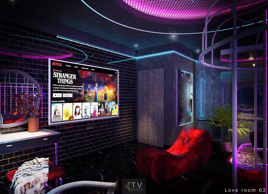 • Nội thất nổi bật: Giường tròn bọc nỉ hồng – trắng, tạo sự mềm mại và thu hút thị giác. Tranh tường Art Pop với hoa hồng và gương mặt nghệ thuật phong cách 3D, là điểm nhấn chủ đạo của phòng. Ghế thư giãn đơn sắc tông đỏ, form dáng hiện đại. Vách kính kết hợp đèn viền Neon, mở rộng không gian và tăng hiệu ứng ánh sáng. Bàn nhỏ tròn kính, kết hợp nội thất đồng bộ màu sắc. • Màu sắc: