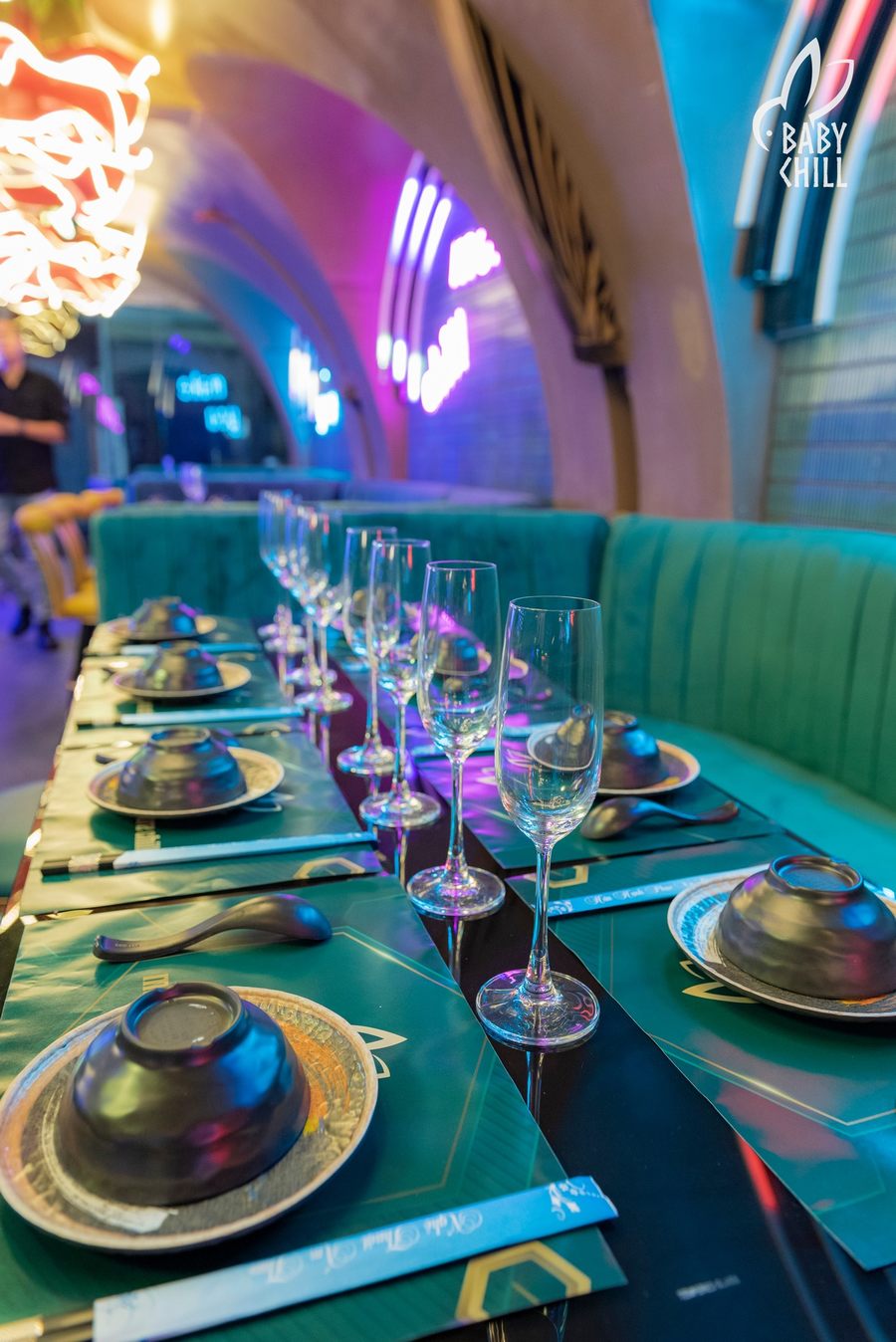 Không gian nhà hàng lounge hiện đại với bàn dài bố trí thẳng hàng, ánh sáng neon dịu nhẹ, ghế băng êm ái, tạo cảm giác sang trọng, phù hợp kinh doanh ẩm thực kết hợp trải nghiệm thư giãn 