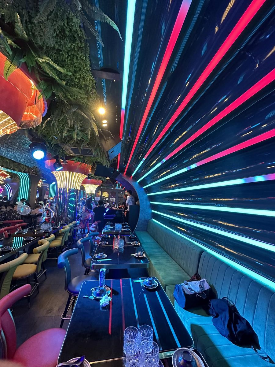 Không gian nhà hàng lounge với ánh sáng LED rực rỡ, tạo hiệu ứng thị giác mạnh, thu hút khách hàng trẻ trong mô hình kinh doanh F&B hiện đại. 