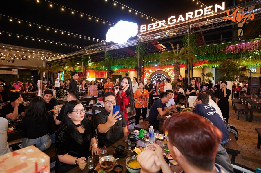Hình ảnh khách hàng trò chuyện vui vẻ trong beer garden thể hiện không khí nhộn nhịp, phù hợp cho các buổi gặp gỡ bạn bè và tổ chức tiệc nhỏ. 