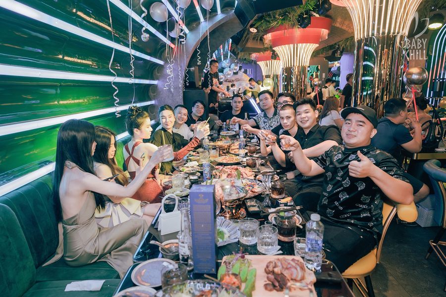 Không gian nội thất nhà hàng lounge bar với ánh sáng nhiều màu sắc, tạo cảm giác năng động và thu hút khách trẻ.