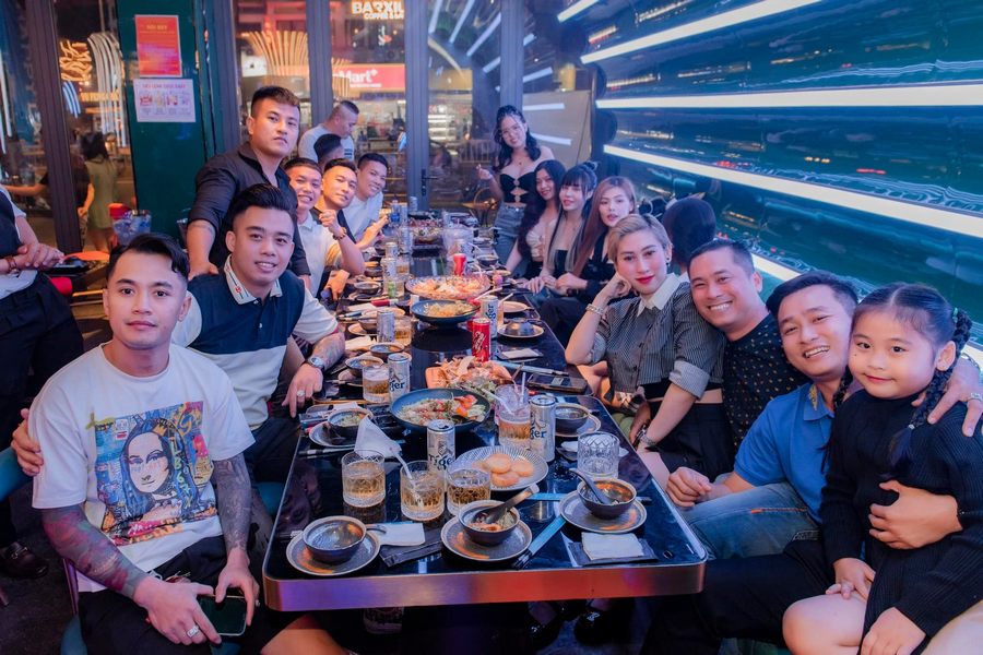 Bàn ăn nhóm trong nhà hàng lounge với bố trí linh hoạt, phù hợp tổ chức tiệc nhỏ và gặp mặt bạn bè Nội thất ghế sofa và bàn cao trong lounge bar tạo sự thoải mái và trải nghiệm ăn uống hiện đại 