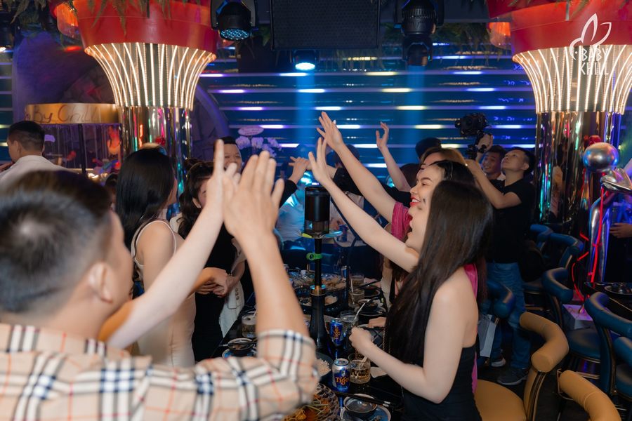 Khu vực bàn trong mô hình lounge bar tương tác với đồ uống, ánh sáng nghệ thuật, bố trí hợp lý giúp nâng cao trải nghiệm khách hàng.