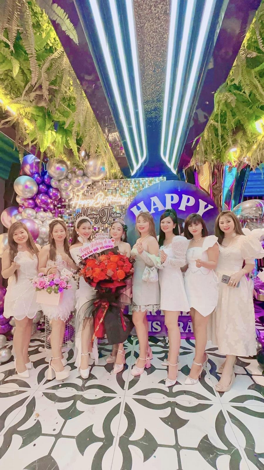 Không gian nhà hàng lounge được trang trí tiệc sinh nhật với bóng bay, backdrop ánh sáng và nhóm khách tạo dáng chụp hình, mang đến trải nghiệm ăn uống kết hợp giải trí trong mô hình F&B hiện đại, thu hút khách trẻ và tạo điểm check-in ấn tượng