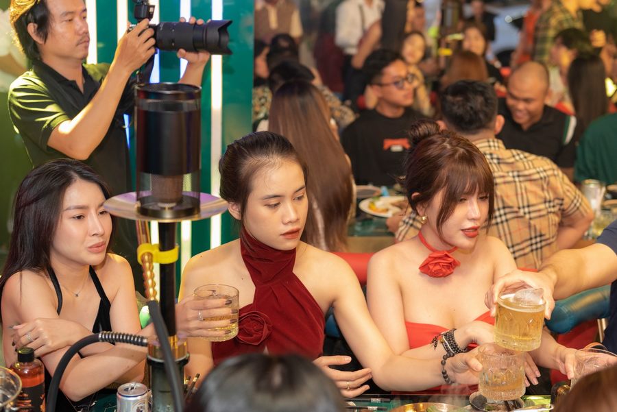 Không gian mô hình nhà hàng lounge bar với ánh sáng nghệ thuật, khách hàng trẻ giao lưu, bàn ghế bố trí linh hoạt tạo cảm giác sôi động và kết nối. Thiết kế lounge bar hiện đại với cột trang trí ánh sáng, khách hàng trải nghiệm không gian giải trí, phù hợp xu hướng kinh doanh đô thị. 