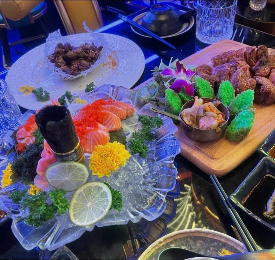 Món ăn được bày trí sáng tạo với rau xanh và gia vị, tạo điểm nhấn thị giác trong không gian nhà hàng hiện đại